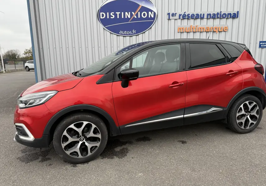 Profil droit d'un Renault Captur rouge 2017 avec jantes alliage bicolores et toit noir contrasté.