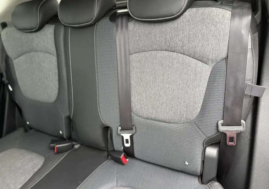 Vue rapprochée des sièges arrière gris et noirs du Renault Captur TCE 120 EDC Intens, avec ceintures de sécurité visibles.