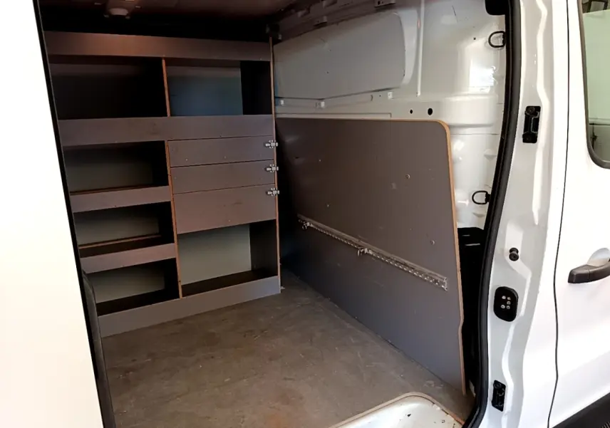 Vue intérieure côté droit du Renault Trafic Fourgon blanc 2021, montrant les étagères de rangement et l'espace de chargement.