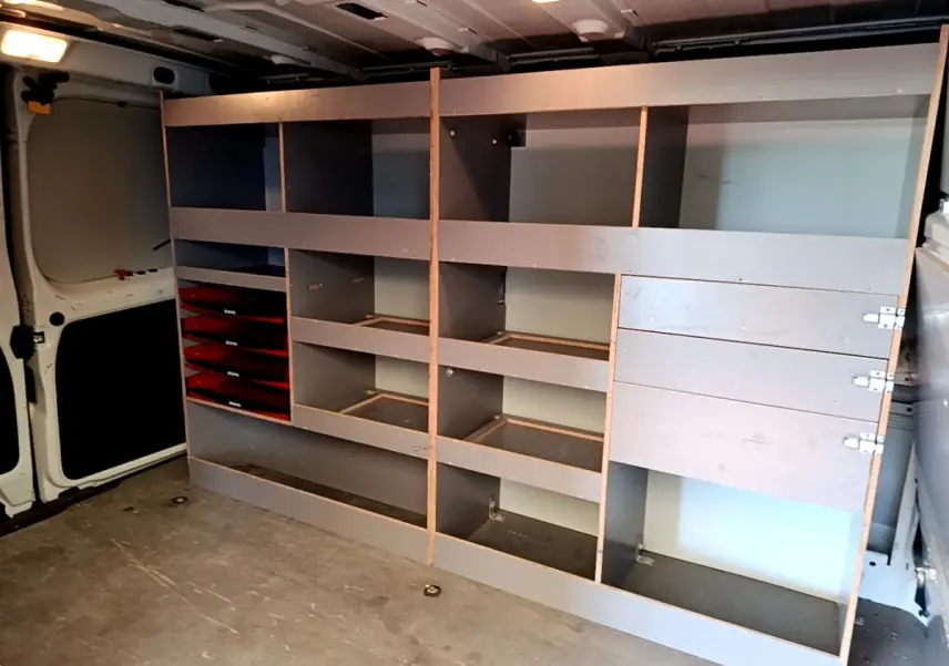 Vue intérieure du Renault Trafic Fourgon blanc 2021, montrant les étagères de rangement côté droit du compartiment de chargement.