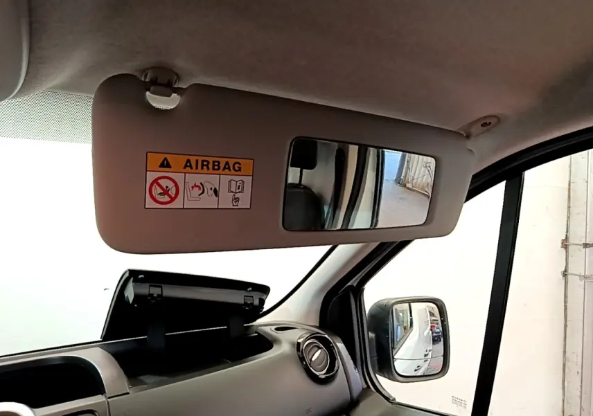 Vue intérieure côté passager du Renault Trafic Fourgon blanc 2021, avec pare-soleil et rétroviseur extérieur visible.