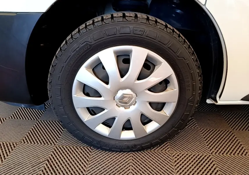 Gros plan sur la roue avant droite du Renault Trafic Fourgon blanc, avec enjoliveur argenté et logo Renault central.