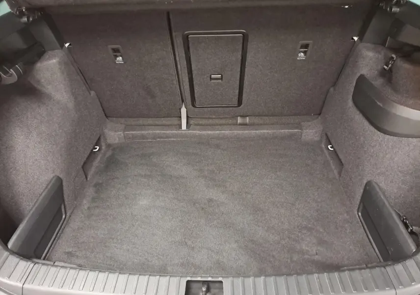 Coffre spacieux et vide du Skoda Karoq 2025, vue intérieure arrière avec revêtement tissu gris foncé.