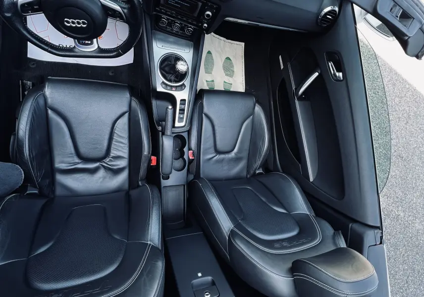 Vue intérieure de l'Audi TT RS Roadster 2009 cabriolet, sièges baquet cuir noir et tableau de bord avec boîte manuelle.