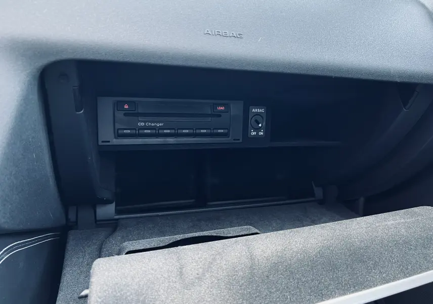 Intérieur de l'Audi TT RS Roadster 2009 montrant le lecteur CD dans la boîte à gants ouverte côté passager.