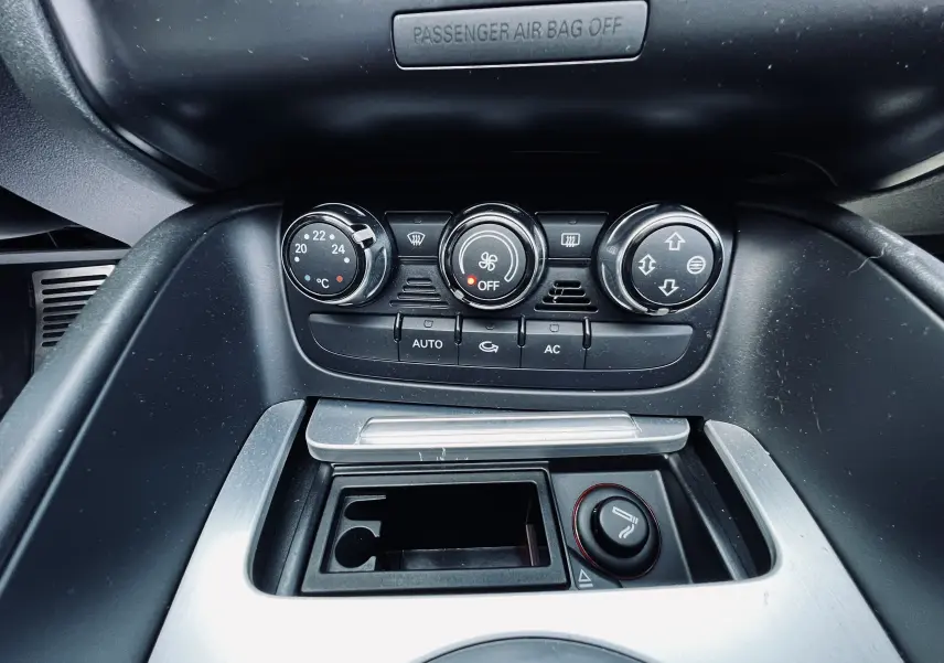 Vue rapprochée du tableau de bord de l'Audi TT RS Roadster 2009 montrant les commandes de climatisation et l'allume-cigare.