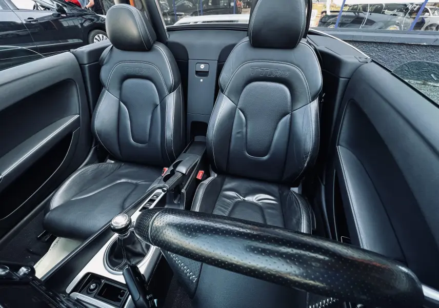 Intérieur noir en cuir de l'Audi TT RS Roadster 2009, vue rapprochée des sièges baquets et levier de vitesse manuel.