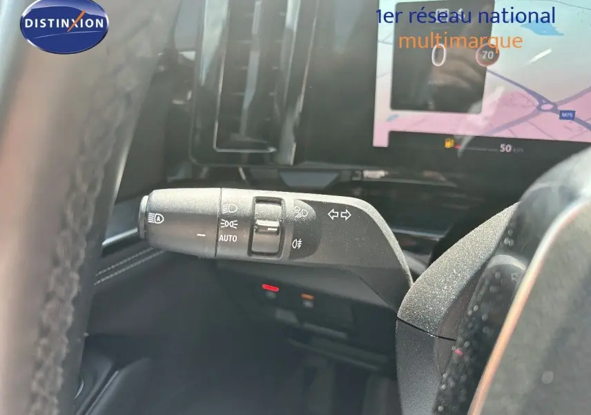 Le commodo des phares et clignotants du Renault Austral gris schiste, avec écran tactile en arrière-plan.