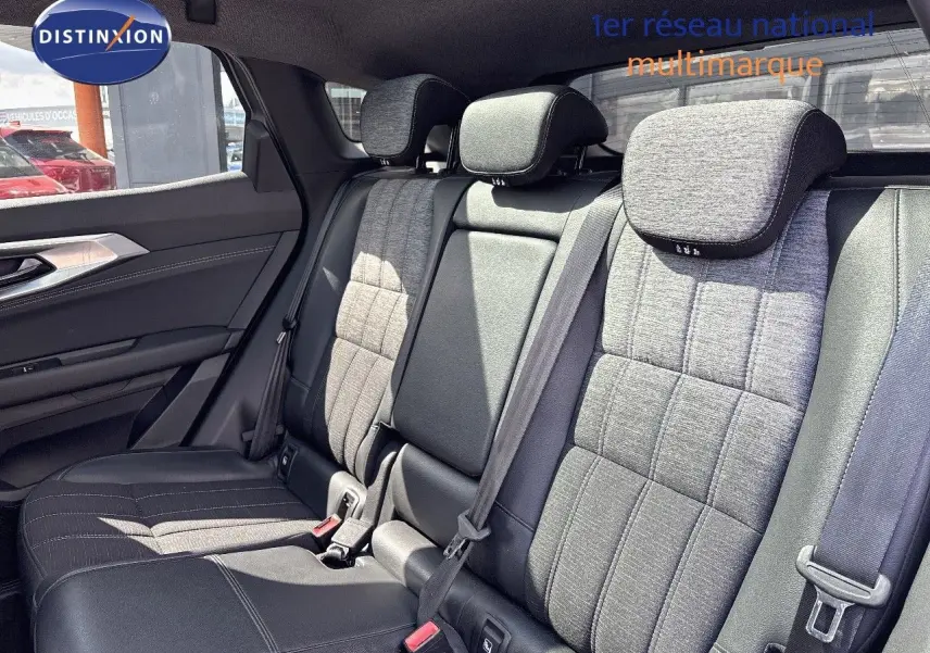 Vue intérieure arrière des sièges du Renault Austral 2024, tissu gris clair et cuir noir, avec appuie-têtes et ceintures visibles.