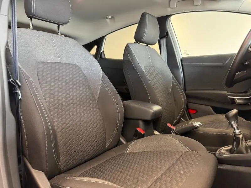 Intérieur du Ford Puma 2023 vu côté droit, sièges tissu gris avec coutures blanches et accoudoir central noir.