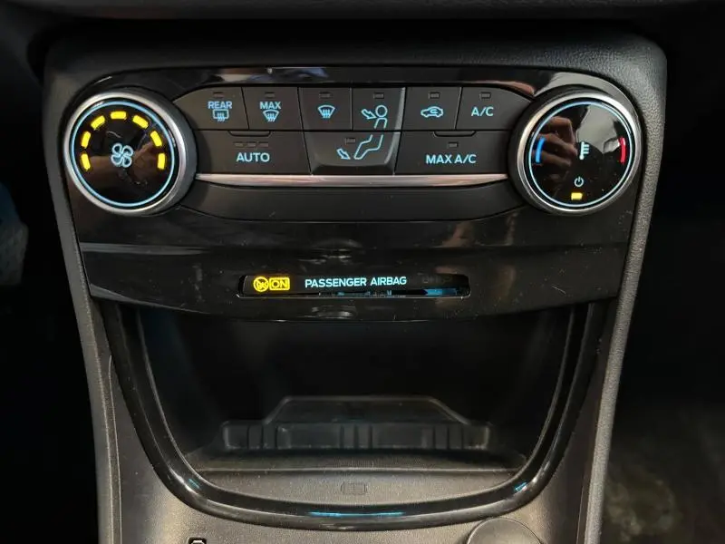 Détail du tableau de bord du Ford Puma 2023 montrant les commandes de climatisation et l'indicateur airbag passager activé.