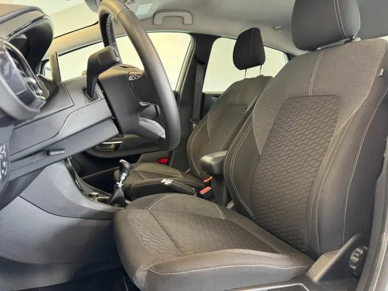 Intérieur avant droit du Ford Puma 2023, sièges noirs avec surpiqûres blanches et volant multifonction visible.