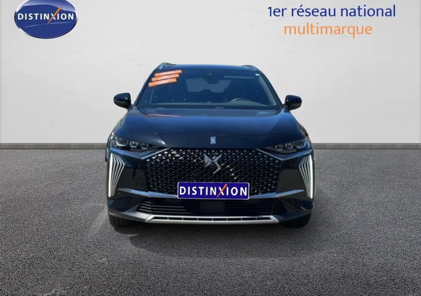 Vue frontale d'un DS7 Noir Métal 2024 avec calandre distinctive et feux LED verticaux allumés.