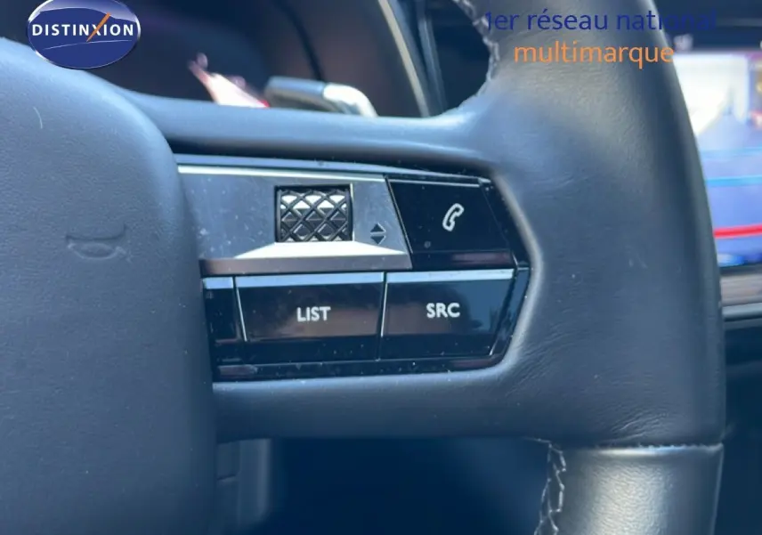 Gros plan sur les commandes gauche au volant cuir noir du DS7 2024 version BlueHDi, avec boutons LIST et SRC visibles.