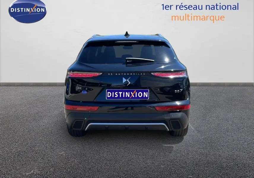 Vue arrière d'un DS7 noir métal 2024 avec feux LED étirés et logo DS centré sur un fond neutre.