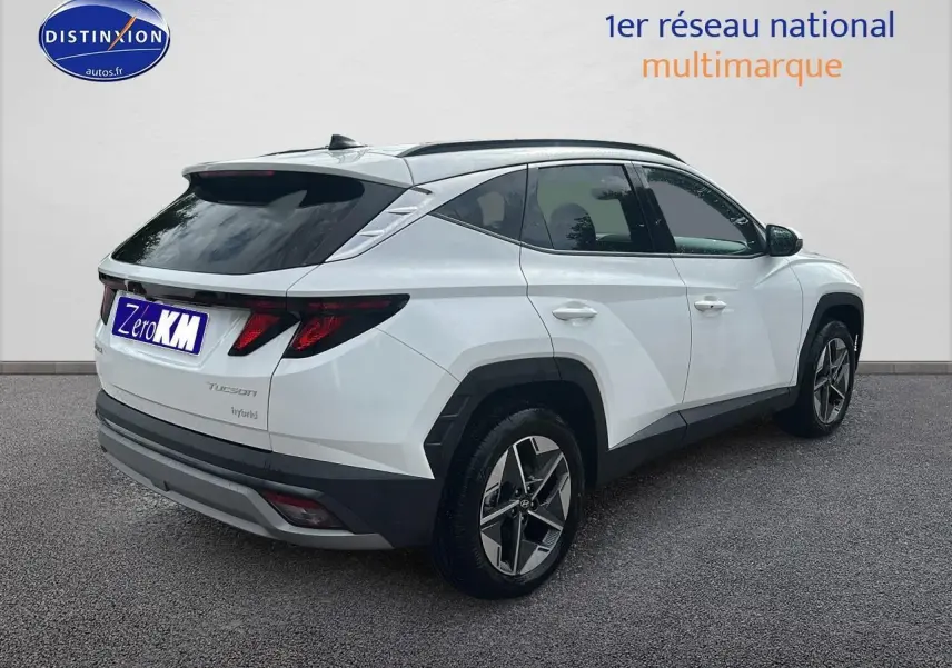 Vue 3/4 arrière droite d'un Hyundai Tucson blanc sérénité avec jantes alliage et vitres teintées.
