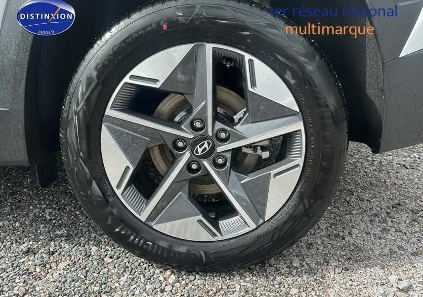 Gros plan sur la jante avant droite en alliage du Hyundai Tucson blanc Sérénité 2025 avec logo Hyundai central.