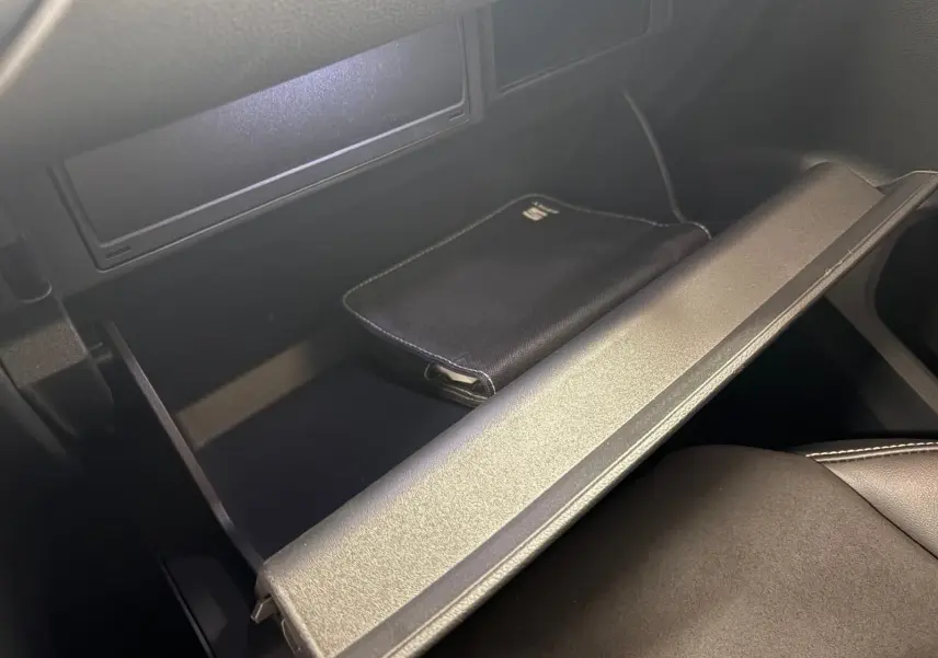 Vue rapprochée de la boîte à gants ouverte du SEAT Ateca 2024 avec pochette noire à l’intérieur, intérieur noir.