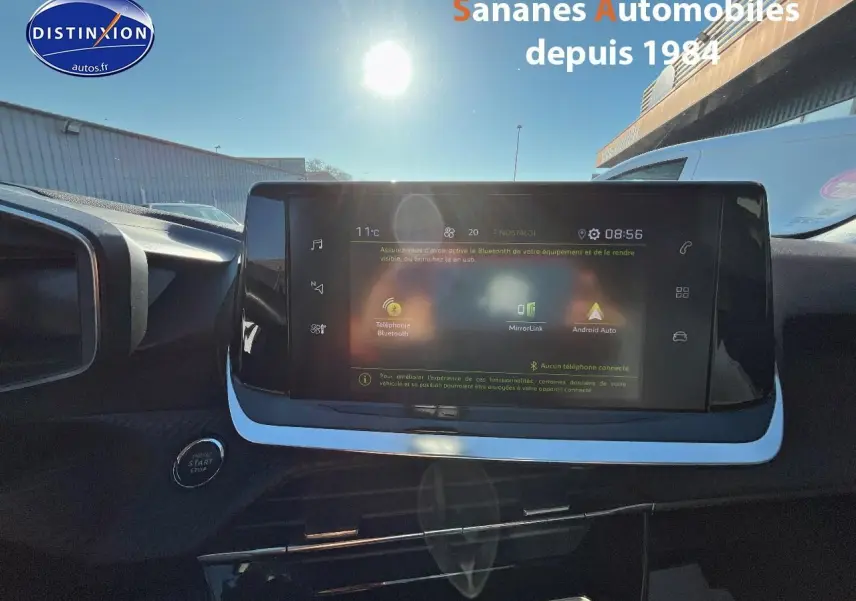 Vue intérieure du tableau de bord du Peugeot 2008 blanc de 2020, avec écran tactile central et bouton démarrage visible.