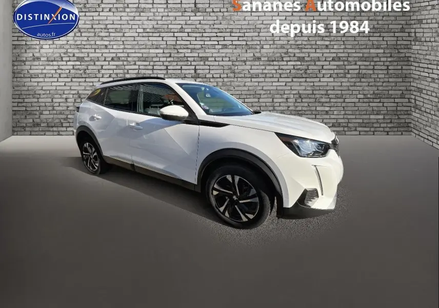 Peugeot 2008 blanc en 3/4 avant droit, avec jantes alliage bi-tons et feux diurnes LED visibles.