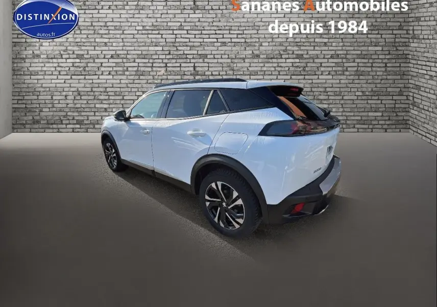 Peugeot 2008 blanc vue 3/4 arrière droit, jantes alliage bi-ton et toit noir contrasté.