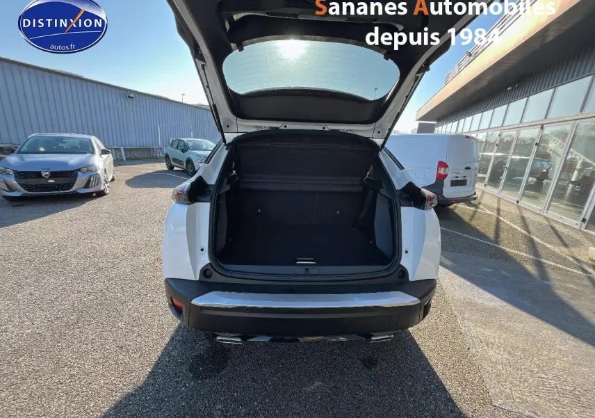 Vue arrière d'un Peugeot 2008 blanc 2020 avec coffre ouvert, montrant l'espace de chargement vide.
