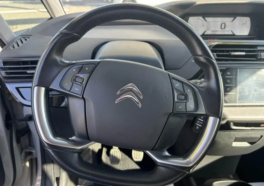 Vue rapprochée du volant multifonction noir du Citroën Grand C4 Spacetourer 2018 avec tableau de bord numérique en arrière-plan.