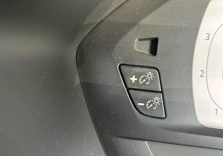 Gros plan sur les boutons de réglage du régulateur de vitesse et des phares du tableau de bord du Citroën Grand C4 Spacetourer beige clair.