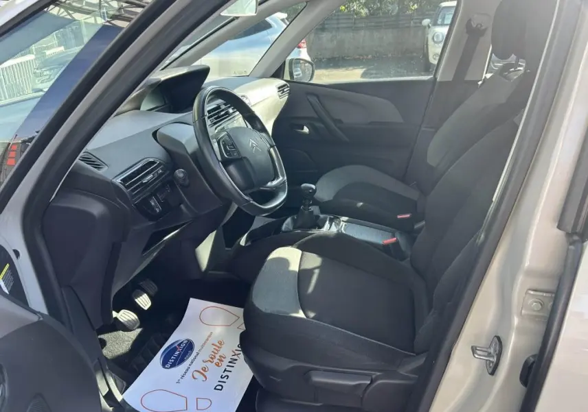 Vue intérieure côté conducteur du Citroën Grand C4 Spacetourer beige clair, montrant sièges et volant avec boîte manuelle.