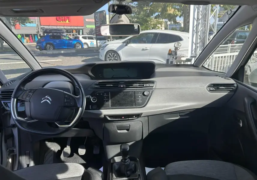 Vue intérieure avant du Citroën Grand C4 Spacetourer 2018, tableau de bord gris avec volant multifonction et boîte manuelle.