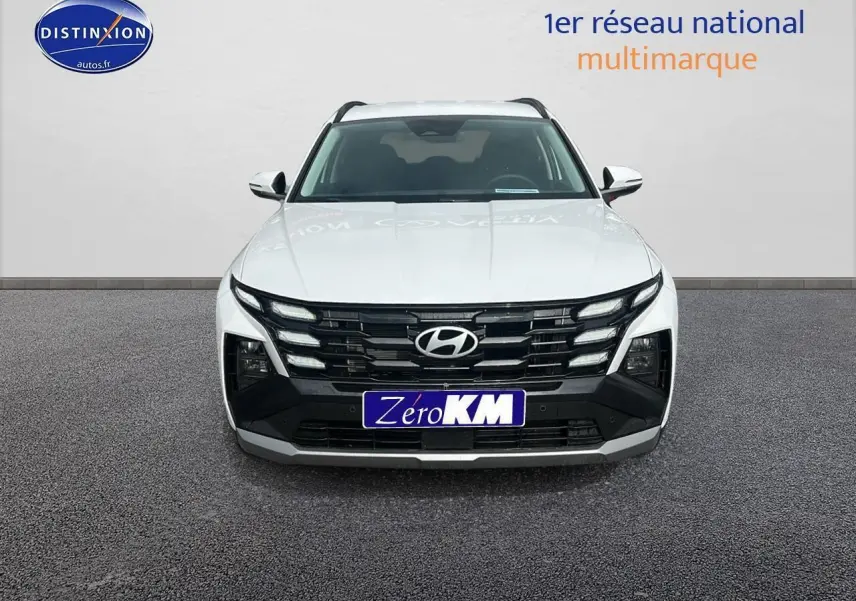 Vue frontale d'un Hyundai Tucson blanc sérénité avec calandre noire et logo Hyundai bien visible