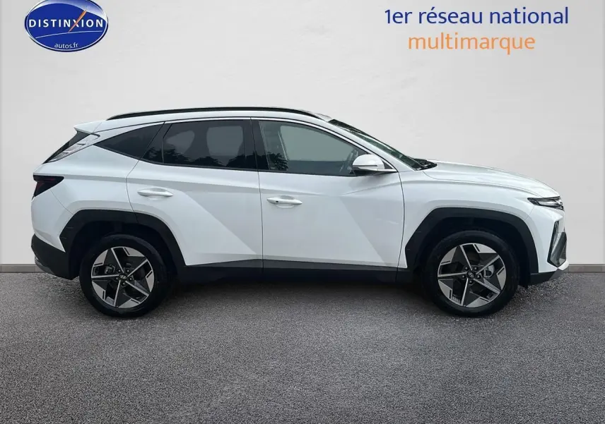 Profil côté gauche du Hyundai Tucson blanc Sérénité 2025 avec jantes alliage et vitres teintées.
