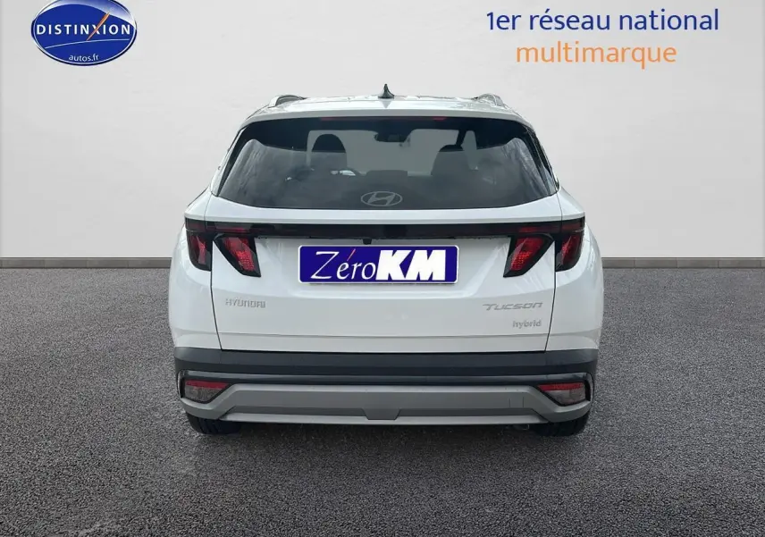 Vue arrière d'un Hyundai Tucson blanc Sérénité 2025 avec feux arrière noirs et logo Hyundai visible sur vitre.