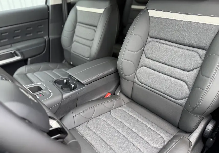 Vue intérieure rapprochée des sièges avant gris clair et foncé en tissu et cuir du Citroën C5 Aircross 2025.