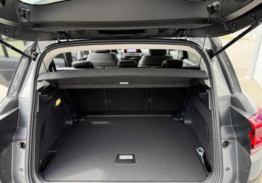 Coffre ouvert vu de l'arrière d'un Citroën C5 Aircross gris platinium métal, espace de chargement spacieux et bien agencé.