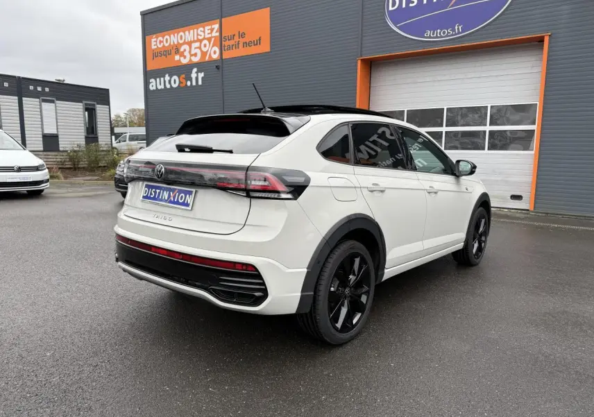 Volkswagen Taigo blanc vue 3/4 arrière droit avec toit noir et jantes noires brillantes sur parking extérieur