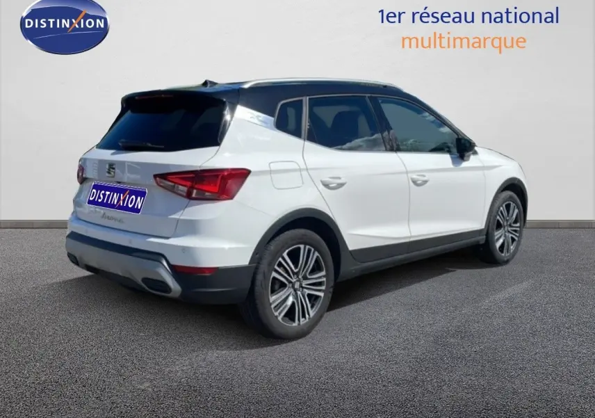 Vue 3/4 arrière droite du SEAT Arona blanc à toit noir, soulignant ses jantes alliage et son design compact.