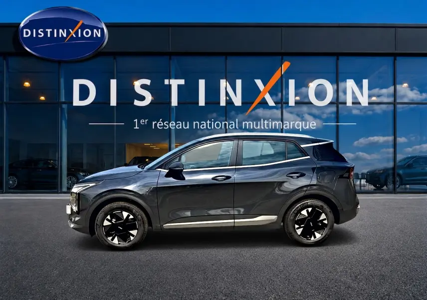 Vue de profil droit du KIA SPORTAGE 1.6 hybride 239 gris eclipse, avec jantes alliage noires et toit noir brillant.