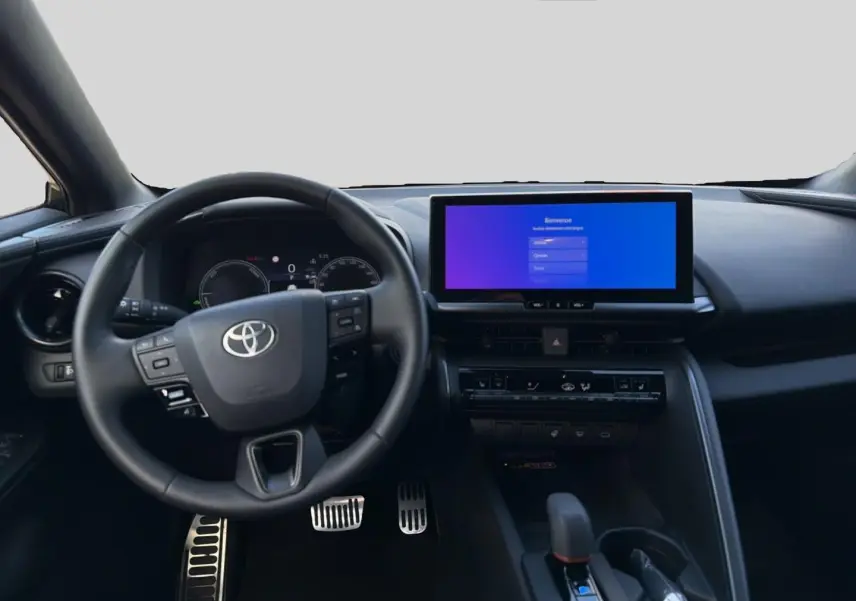 Vue intérieure frontale du tableau de bord noir du Toyota C-HR 1.8 hybride 2025 avec écran tactile large et volant multifonction.