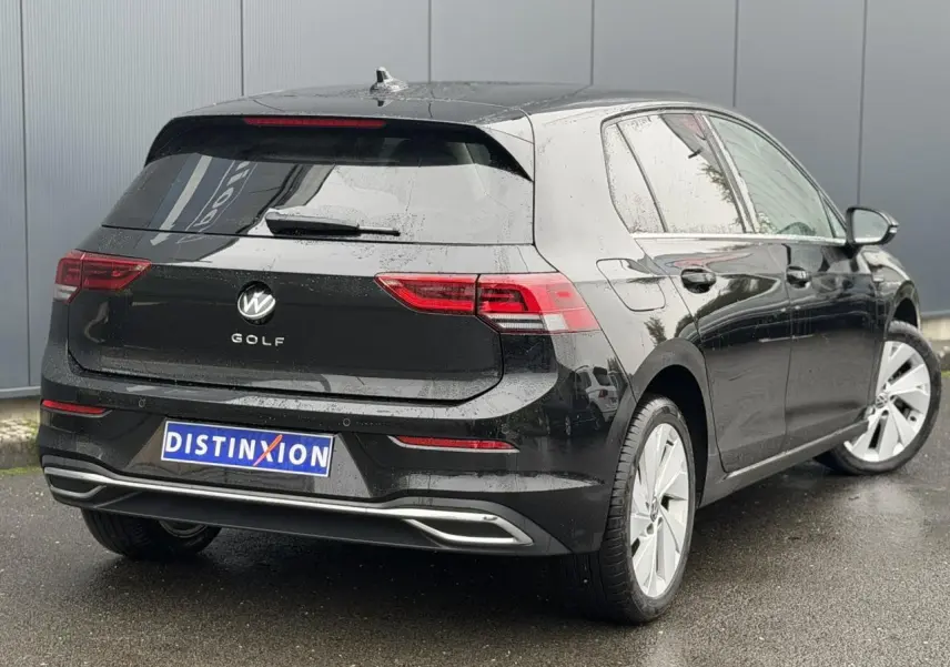 Vue 3/4 arrière droite d'une Volkswagen Golf VIII Deep Black avec feux arrière LED et jantes alliage 17 pouces.