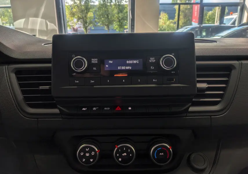 Tableau de bord du Renault Trafic Cabine Approfondie 2023, vue frontale centrée sur la console multimédia et climatisation.