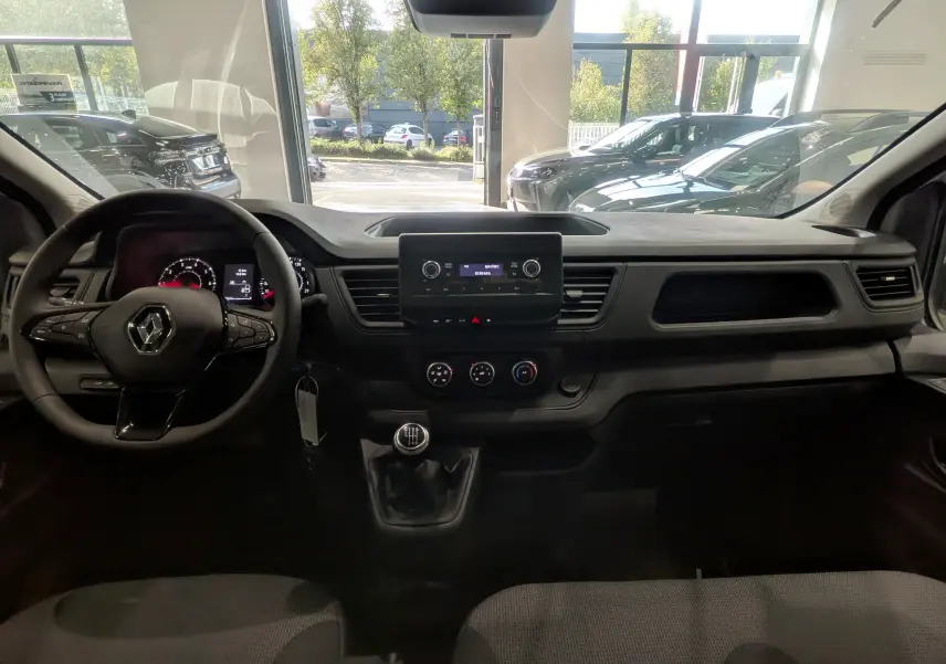 Vue intérieure avant du Renault Trafic Cabine Approfondie blanc minéral 2023, avec tableau de bord et volant multifonction.