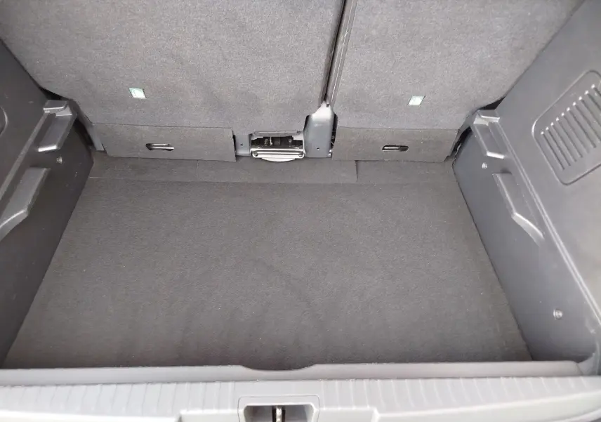 Coffre ouvert du Renault Captur gris Cassiopée, montrant l'espace de chargement et le dossier des sièges arrière.
