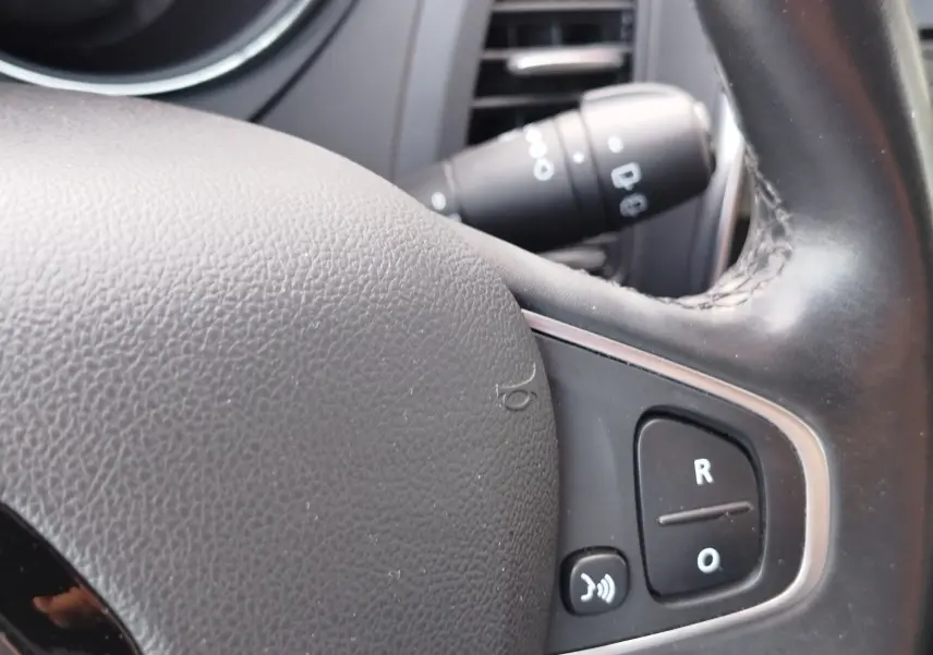 Gros plan sur le volant en cuir noir du Renault Captur 2018, avec commandes vocales et régulateur de vitesse visibles.