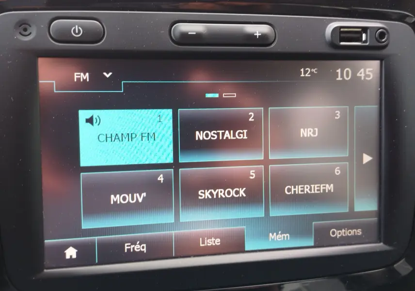 Écran tactile multimédia de Renault Captur affichant les stations FM avec interface noire et boutons physiques.
