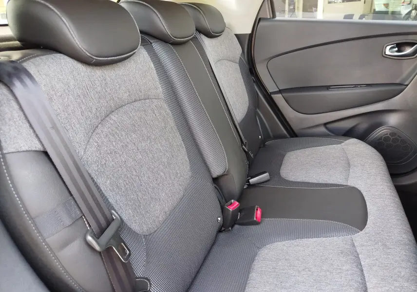 Vue latérale droite des sièges arrière gris et noirs du Renault Captur 2018, soulignant la finition tissu et cuir.