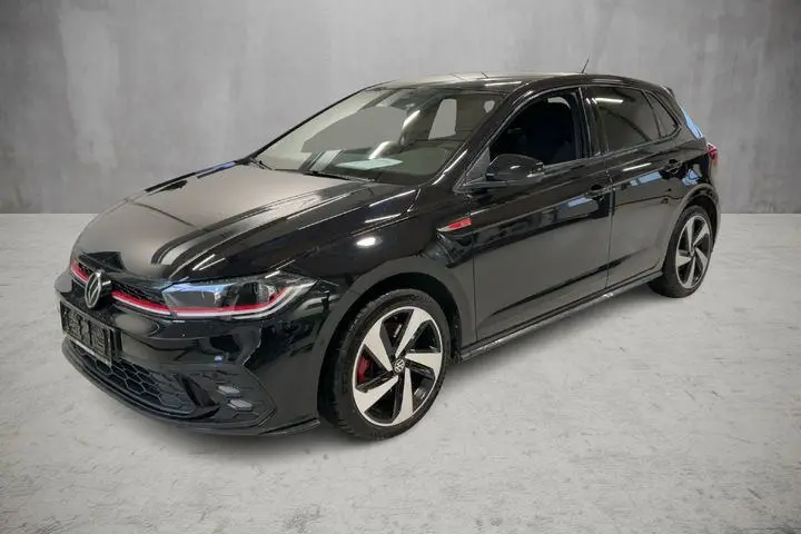 Volkswagen Polo GTI noire vue en 3/4 avant droit, avec jantes alliage 17 pouces et détails rouges sur la calandre.