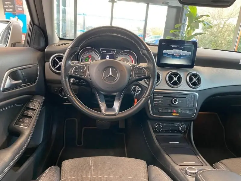 Intérieur du Mercedes GLA 200 Sensation 2017, vue frontale du tableau de bord avec écran central et volant cuir noir.
