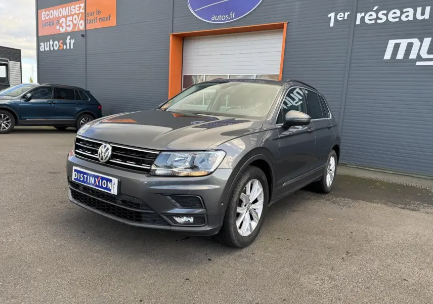 Volkswagen Tiguan gris Indium vu en 3/4 avant droit avec jantes alliage et projecteurs antibrouillard.