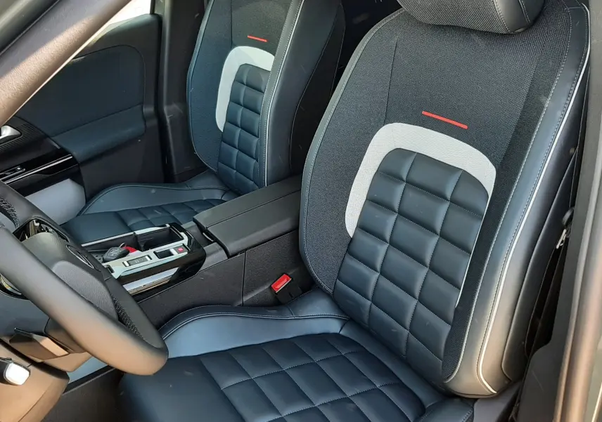 Vue intérieure des sièges avant en cuir et tissu noir avec surpiqûres blanches du Citroën C5 Aircross 2026.